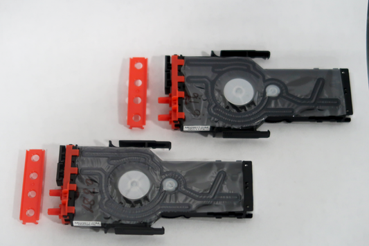 Two black printer cartridges with red clips on a white background