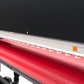 Red conveyor belt with a metal frame on a black background